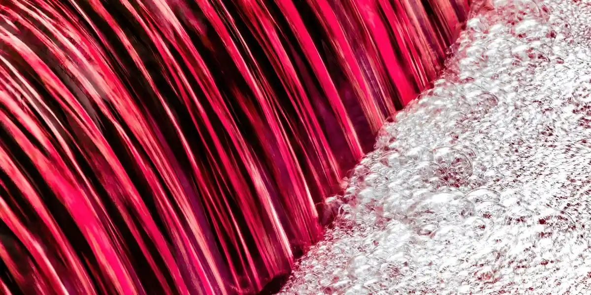 Close-up of a vibrant custom foam background for a gecko terrarium, showing red ridges on the left and white textured foam on the right.
