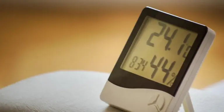 Close-up of a digital hygrometer displaying humidity and temperature readings