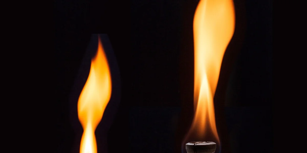 Close-up of two orange flames against a black background, illustrating heat sources used in captive reptile enclosures.