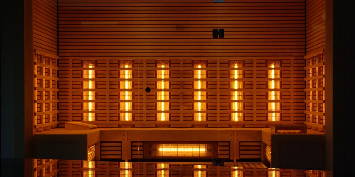 A reptile heating setup with multiple orange-glowing heating elements arranged in a grid inside a cabinet.