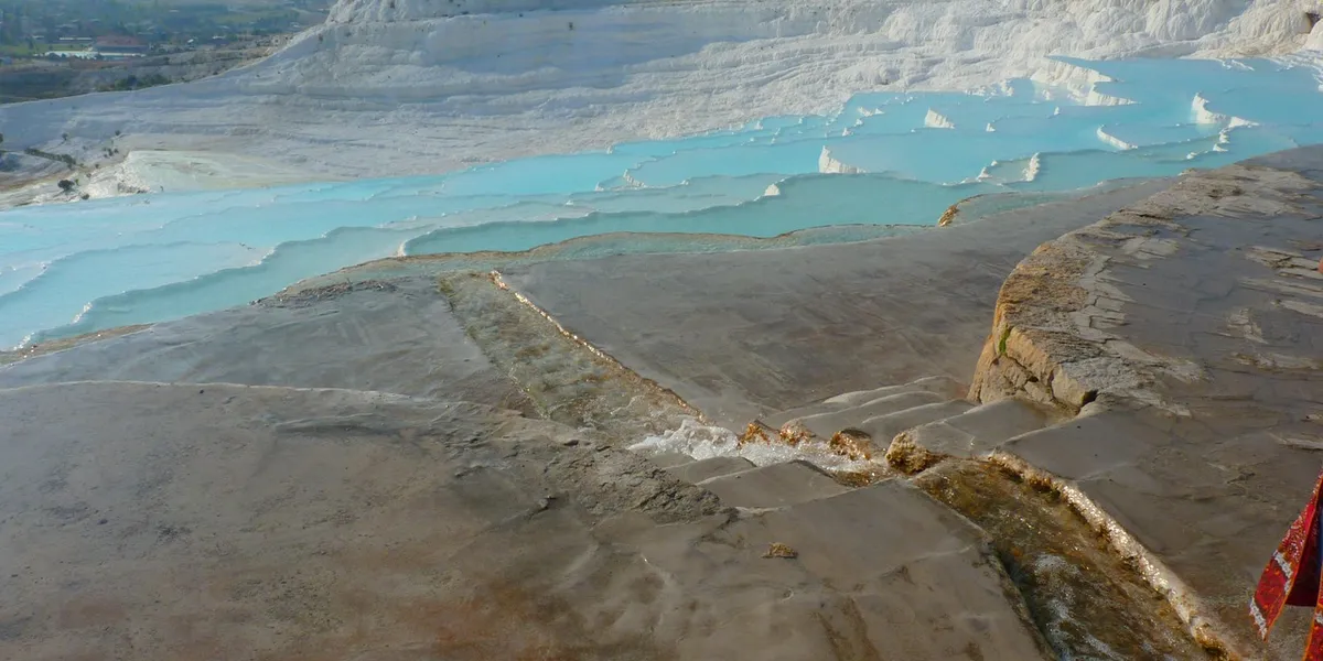 Turquoise mineral terraces and pools at Pamukkale, Turkey, forming layered travertine steps